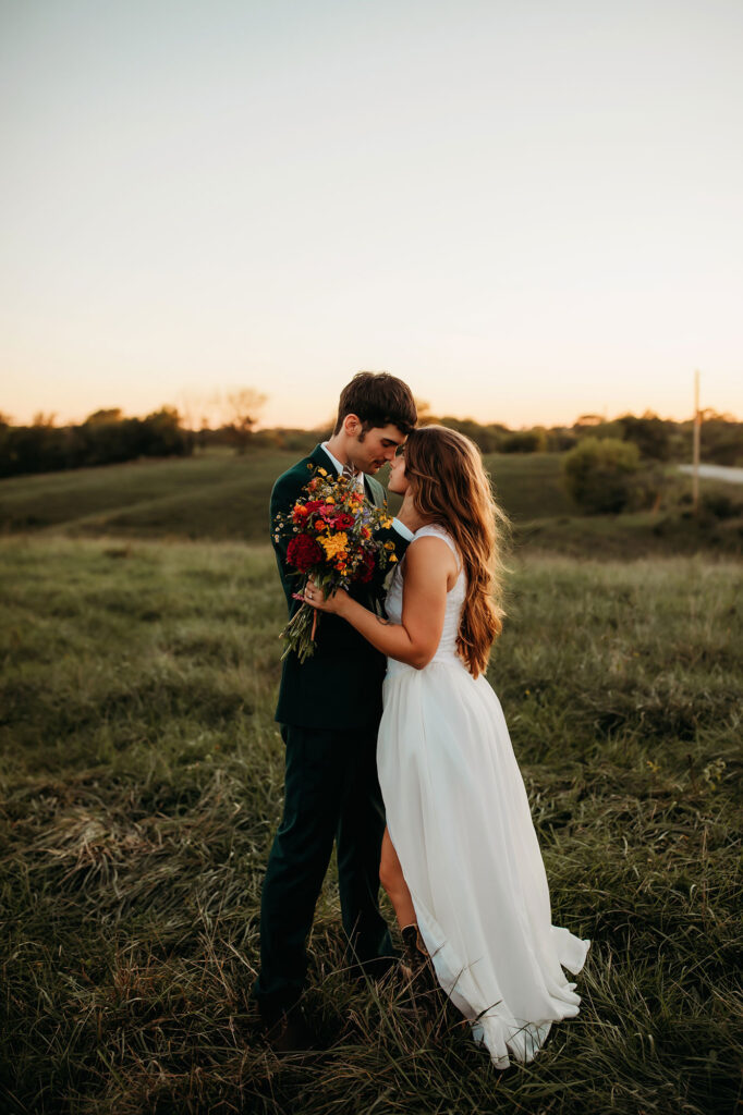 Couple standing in Iowa field on wedding day